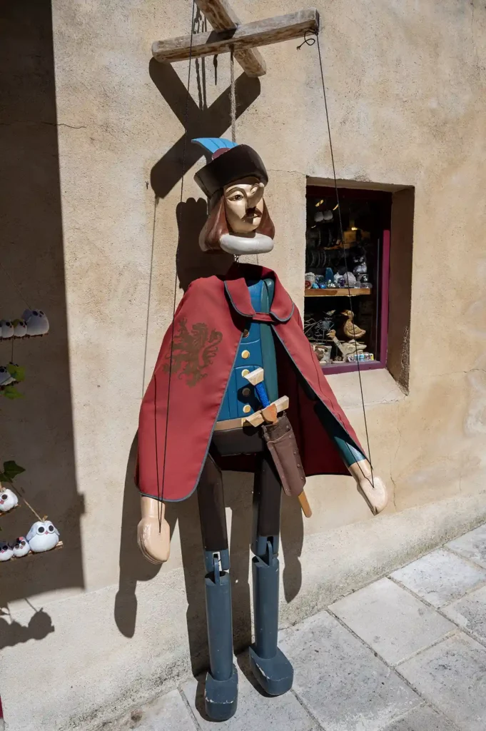 Place de la Mirpe, white stone Cyrano statue and old boatmen’s houses